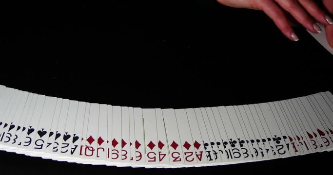 Close up of playing cards spread out across a black table
