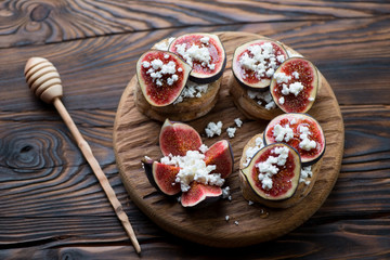 Bruschetta with figs, cheese and honey, rustic wooden setting