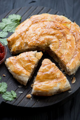 Close-up of sliced burek pie with meat stuffing, selective focus