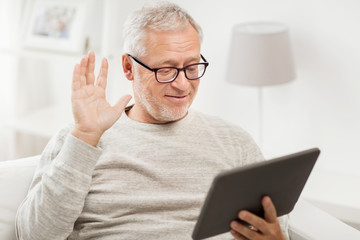 senior man having video call on tablet pc at home