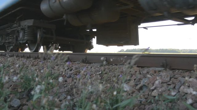 Passenger train passes by a camera. Wheels of the train moving along the rails closeup. Close-up shot of a passenger train passing by. Comfortable traveling by train.