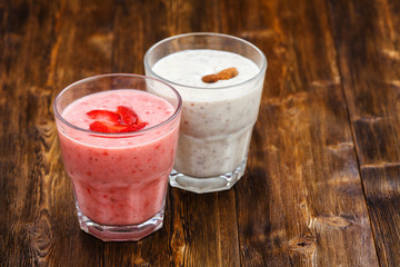 Strawberry and almond milk smoothies in a glass, wooden background