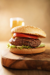 fresh juicy burger with lager beer on oak table