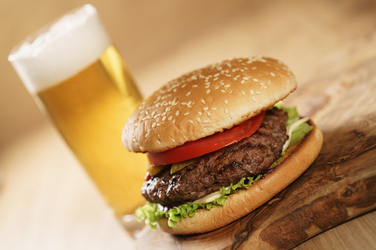 fresh juicy burger with lager beer on oak table