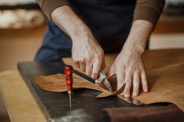 Close-up. Male hand master work with the skin. Small business