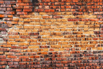 Weathered stained old orange brick wall, texture grunge background
