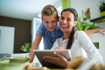 Mother and son using digital tablet in the living room