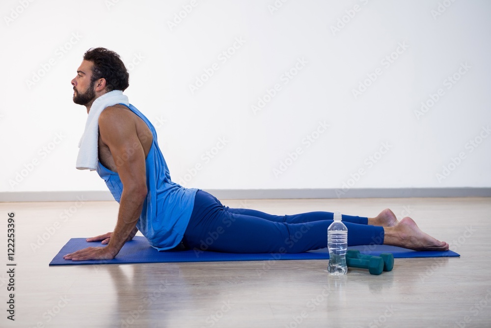 Wall mural Man doing cobra pose on exercise mat