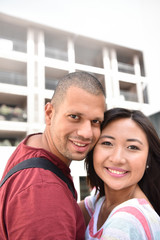 Mixed-race couple embracing each other in town