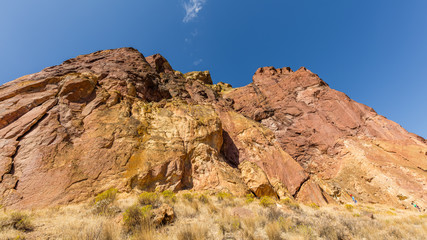 Obraz premium The sheer rock walls. Beautiful landscape of yellow sharp cliffs. Dry yellow grass grows on the slopes of the mountains. Smith Rock state park, Oregon