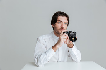 Man ready to make photo while sitting at the table