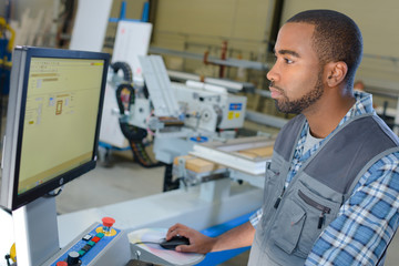 Man operating computer in industrial setting