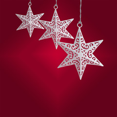 Delicate white star ornaments on Christmas red background, with copy space