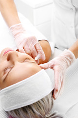 Mezoterapia igłowa, kosmetyczka nakłuwa twarz kobiety. - obrazy, fototapety, plakaty