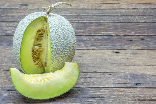 Green melon sliced on wooden table