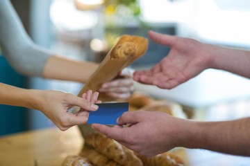 Waitress giving parcel to customer at counter