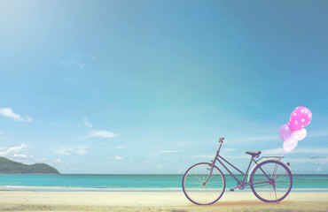 Fototapeta premium vintage bicycle on white sand beach over blue sea and clear blue sky background, spring or summer holiday vacation concept. 