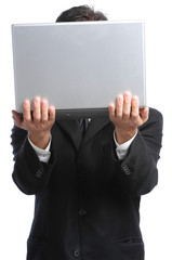 Businessman hiding behind laptop on white