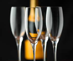 Champagne flutes and bottle on black