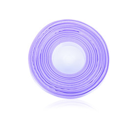 Closeup of purple ribbon roll over white background