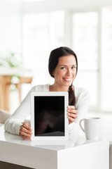 Young woman with digital tablet and coffee in home