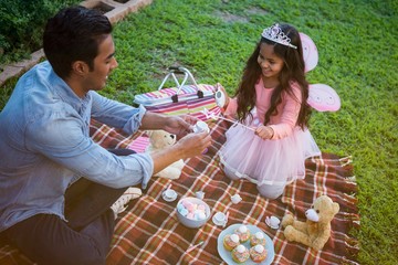 Father and daughter having toy tea party