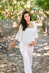 Pregnant woman walking in woods