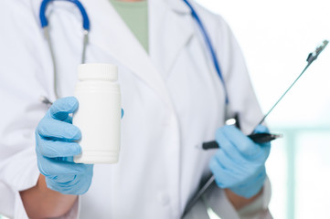 Female doctor holding pill bottle