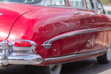 Close-up of an old car. Part of the exterior. An American classic. Chrome lining. Glass with reflection.