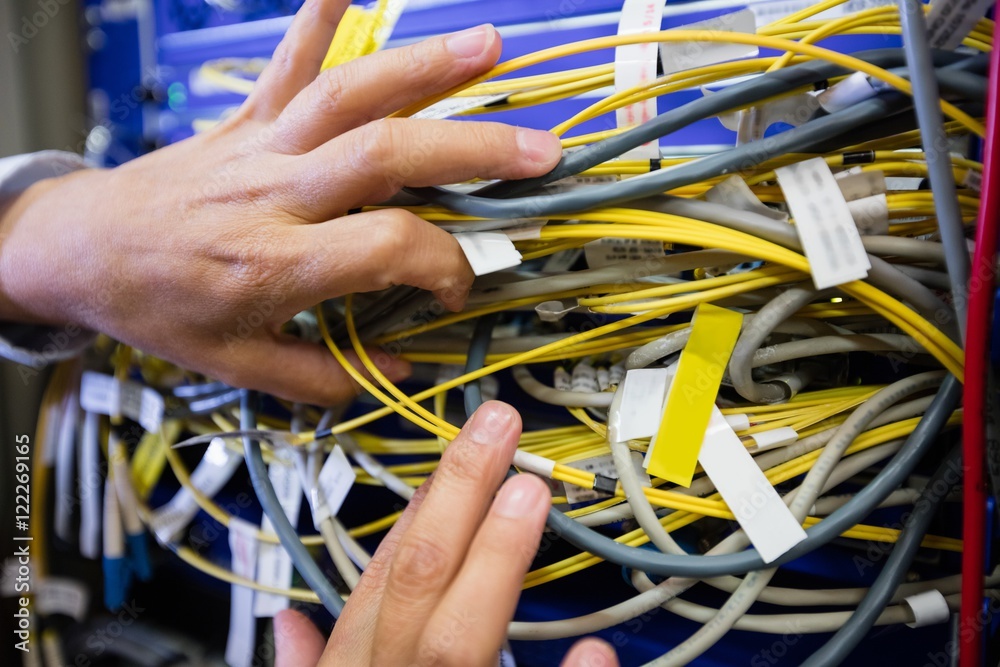Poster technician checking cables in a rack mounted server