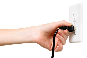 Woman's hand plugging unplugging U.S. electrical cord into outlet isolated on white background for use alone or as a design element