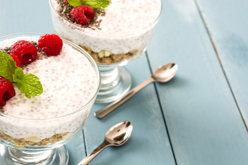 Chia yogurt with raspberries on blue wooden table

