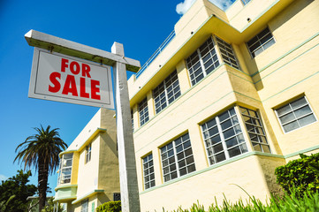 For Sale Sign with art deco condominium apartment building South Beach Miami Florida
