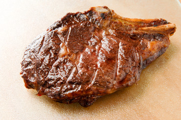 Rib eye steak cooked on glass cutting board