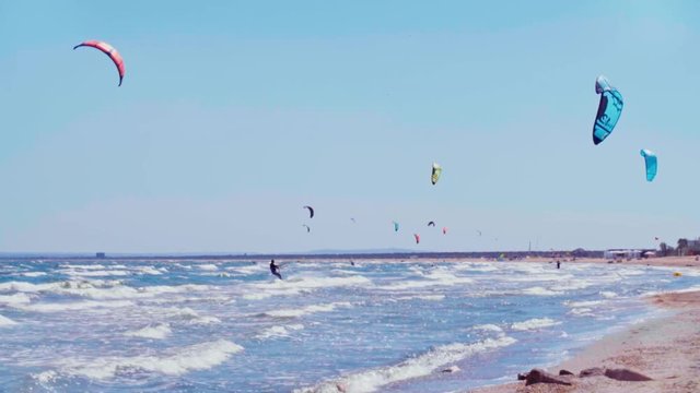 Group of active kite-surfers riding the spot 