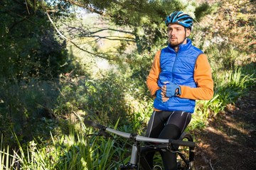 Male mountain holding water bottle standing with bicycle