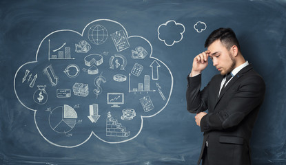 Businessman thinking on background of blackboard with business doodles