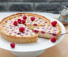 Raspberry, blueberry and white chocolate tart on a white plate Selective focus
