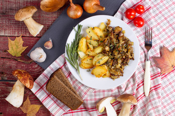 Fried potatoes with cepes in a plate on the table