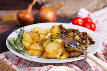 Fried potatoes with cepes in a plate on the table