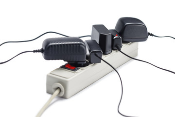 Many plugs plugged in extension cord isolated on white