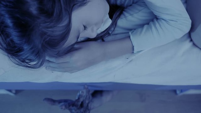monster coming out from under little girls bed. nightmare child. halloween