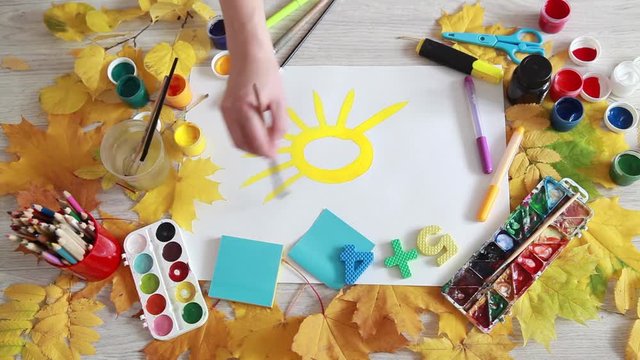 The artist paints a bright yellow sun autumn day
