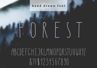 Vector hand drawn font. Modern narrow letters. Hand drawn typography on blurred background