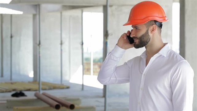 Construction engineer talking on the phone at the building under construction