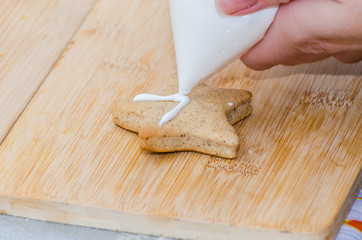 young woman decorates Christmas cookies