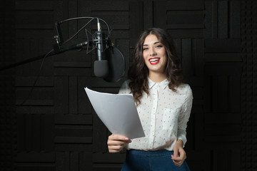 Smiling young woman inside recording station