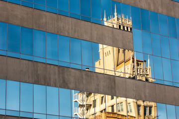 Old Building Reflected In Modern Building Windows
