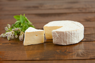 Fresh brie cheese with white mold on a white background