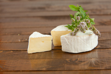 Fresh brie cheese with white mold on a white background
